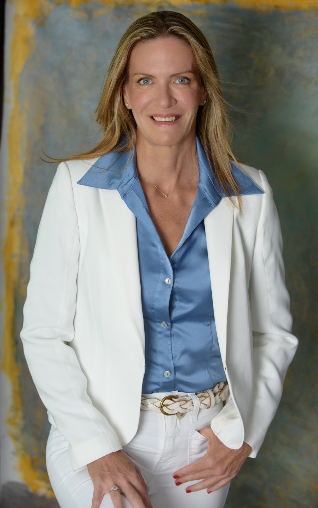 אורית אנגלשטיין בחליפה לבנה עם חיוך.