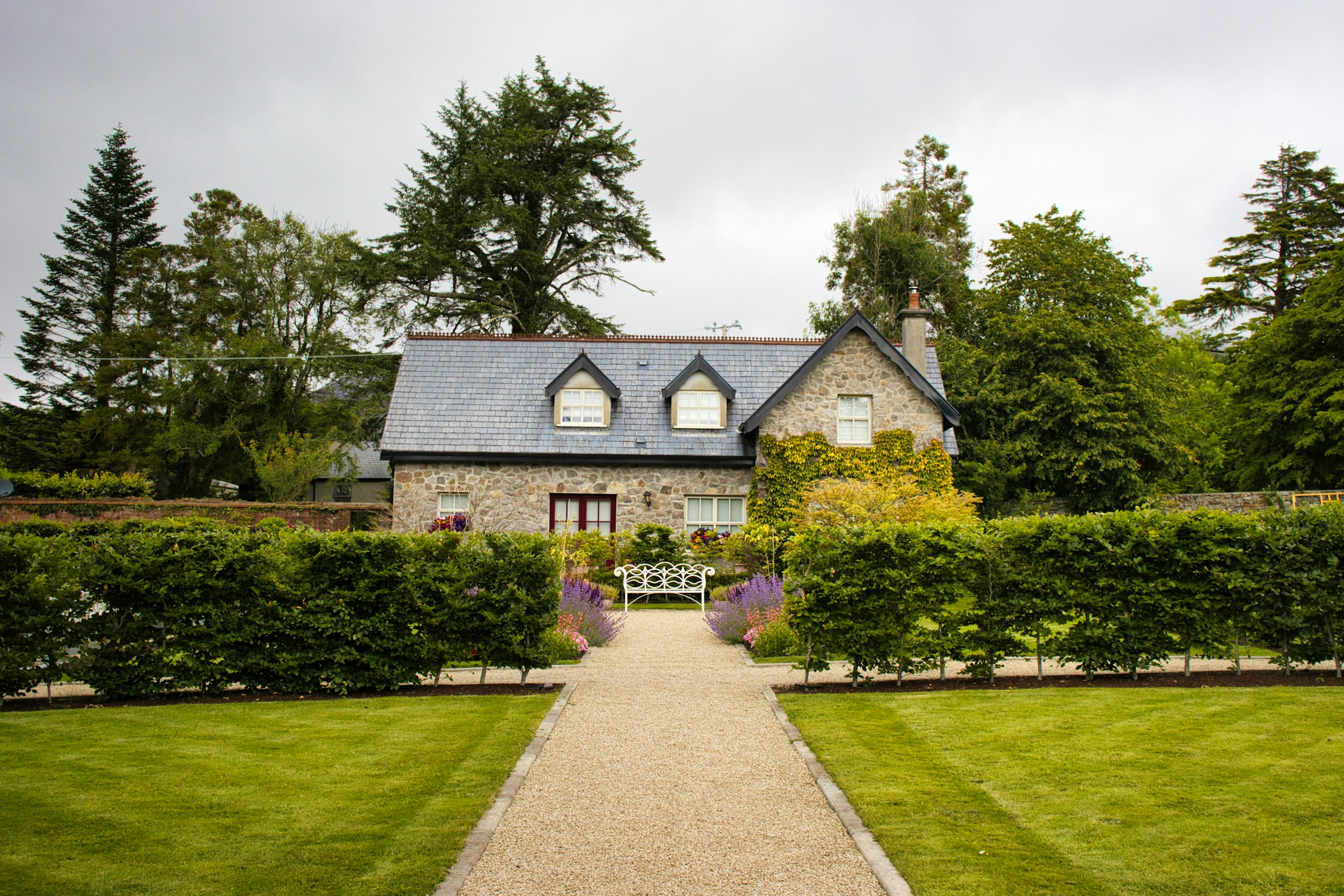 בית פסטורלי במרכז התמונה עם חצר ירוקה, תחושת חזרה הביתה.